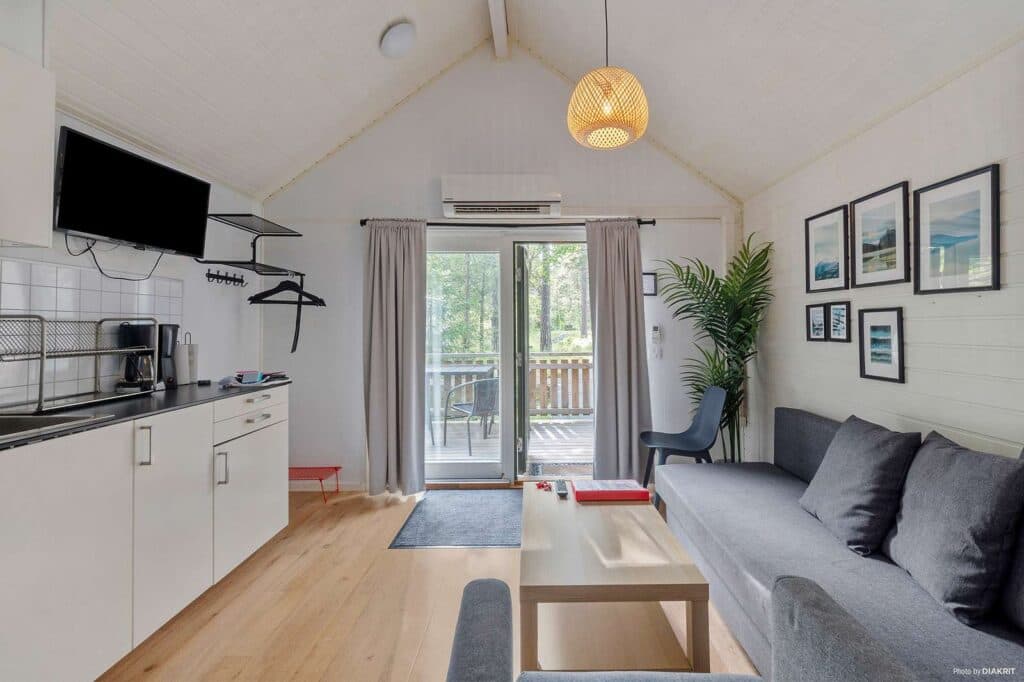 City Stockholm Skarpnäckstuga Plus 2026 interiör bild över altandörren och delar av allrummet med soffa och soffbord