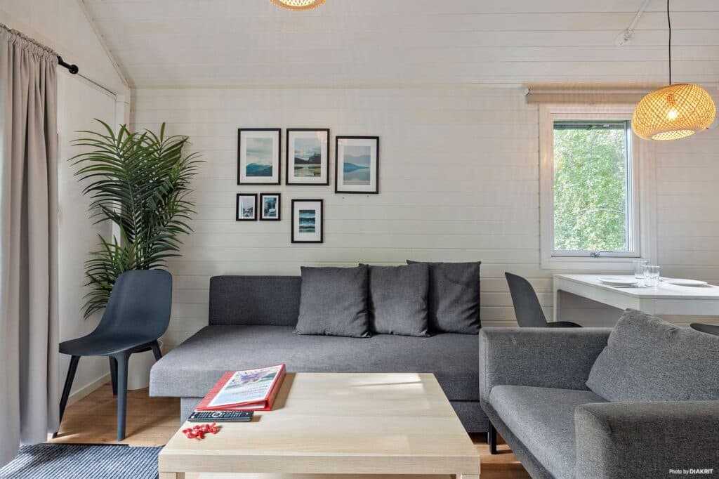 City Stockholm Skarpnäckstuga Plus 2026 interiör bild på allrummet och soffan med tavlor över