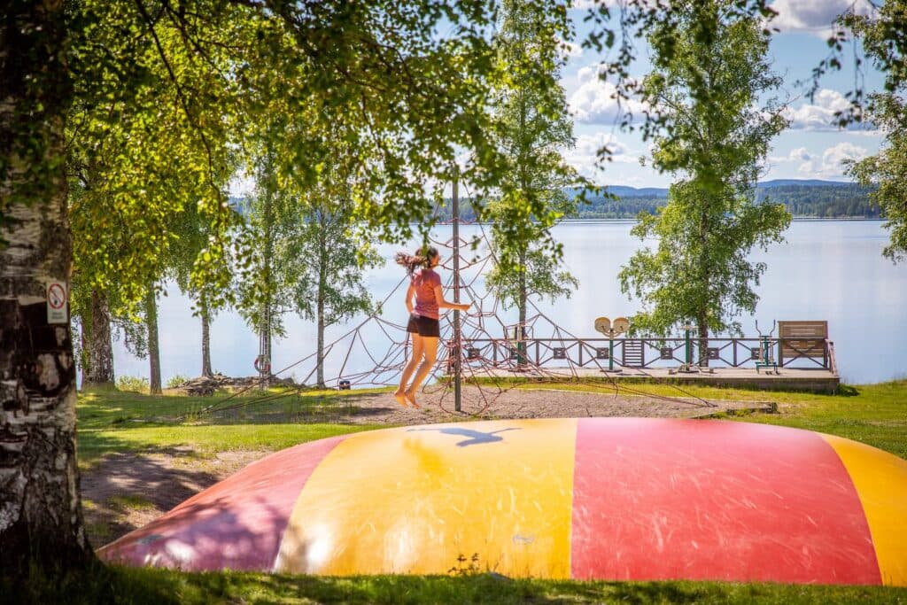 Barn som hoppar på hoppkudde på campingen Haganäset i Charlottenberg